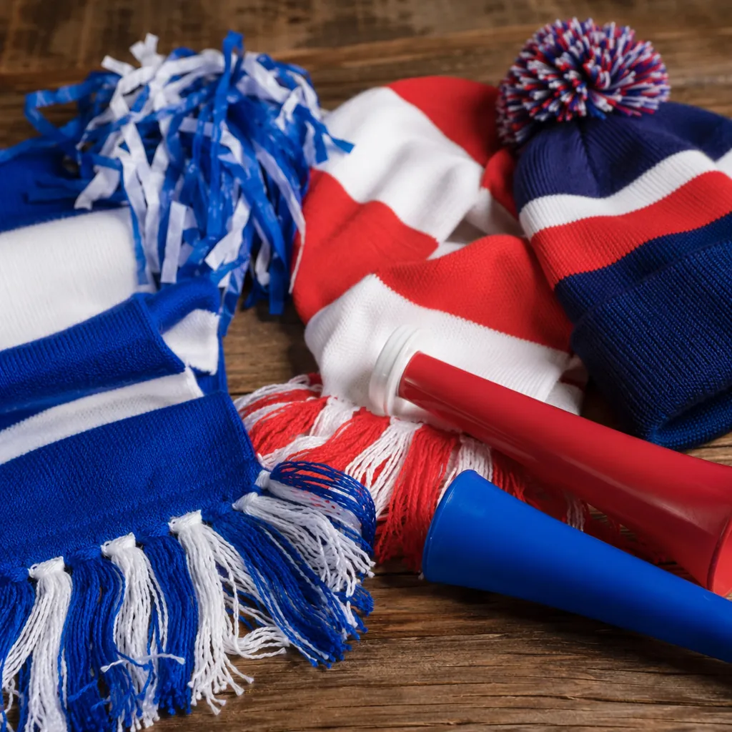 Close up of generic football fan props including team scarves, hats, and noise m